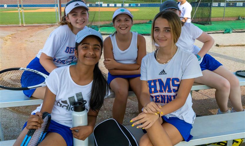 A group of tennis players sits on a bench